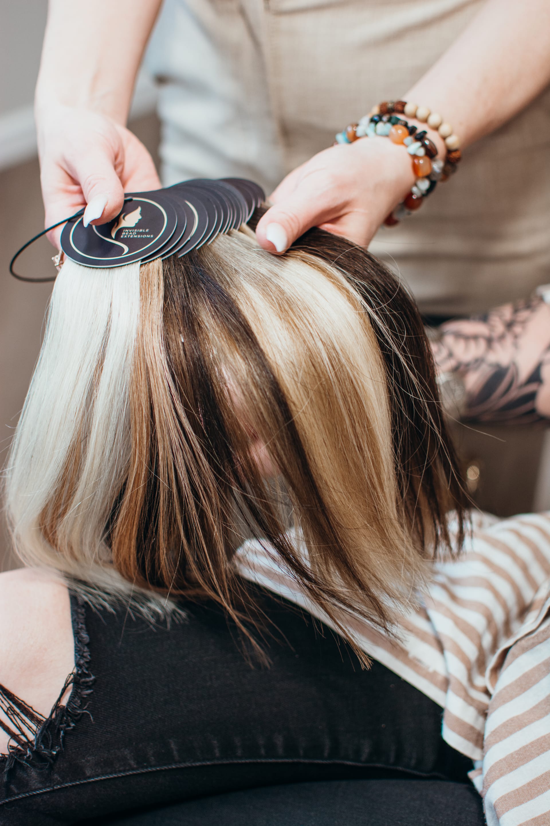 Hair extension color samples fanned out in shades of blonde, brown, and auburn