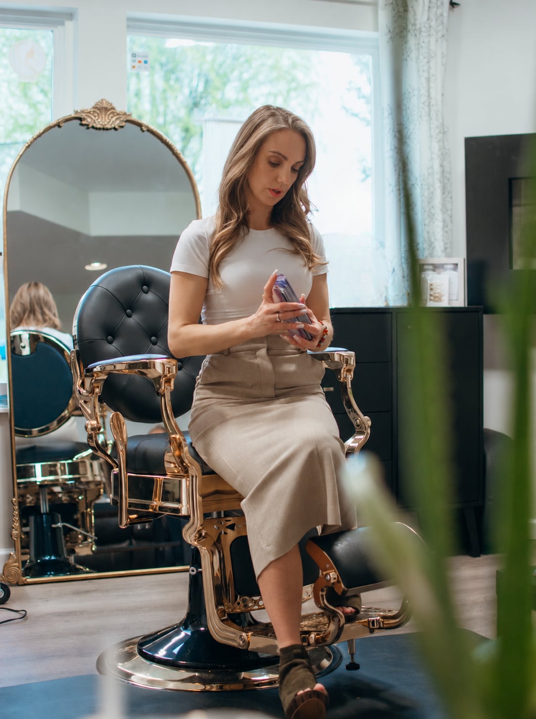Woman seated on a vintage gold salon chair at Amanda Lynn's studio